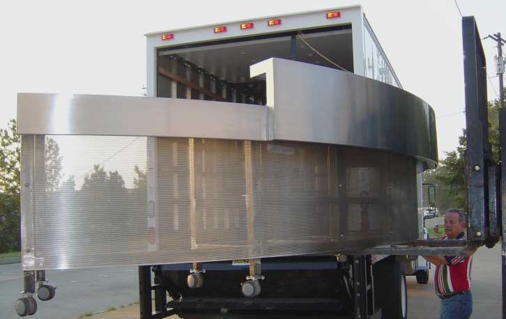 A large truck with the back open on a road.