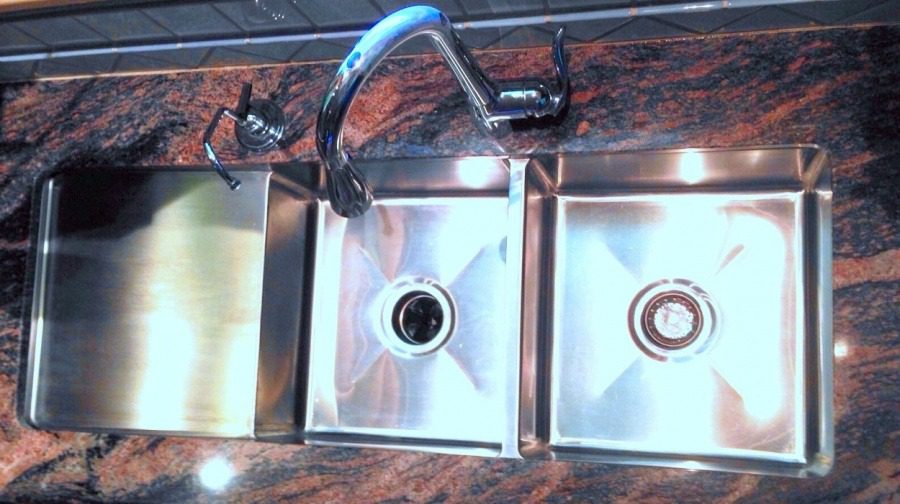 A sink with two sinks and one faucet.