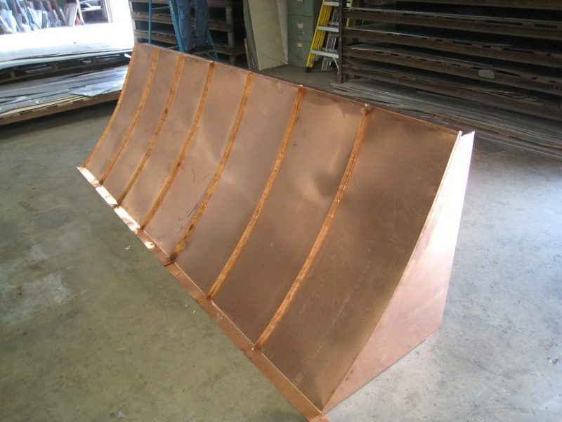 A large copper ramp is sitting in the middle of a warehouse.