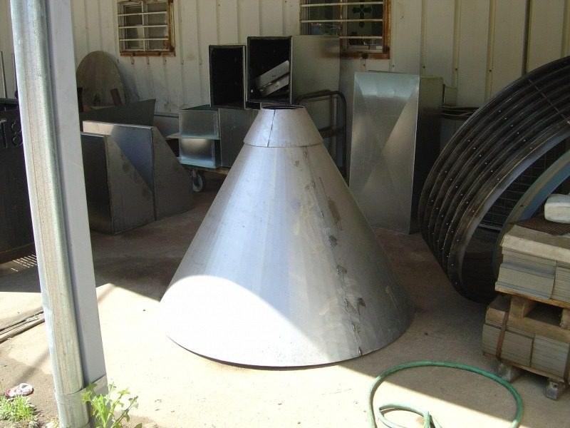 A cone shaped metal object sitting in the middle of a building.