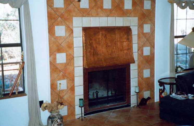 A fireplace with tile and a dog sitting in front of it.